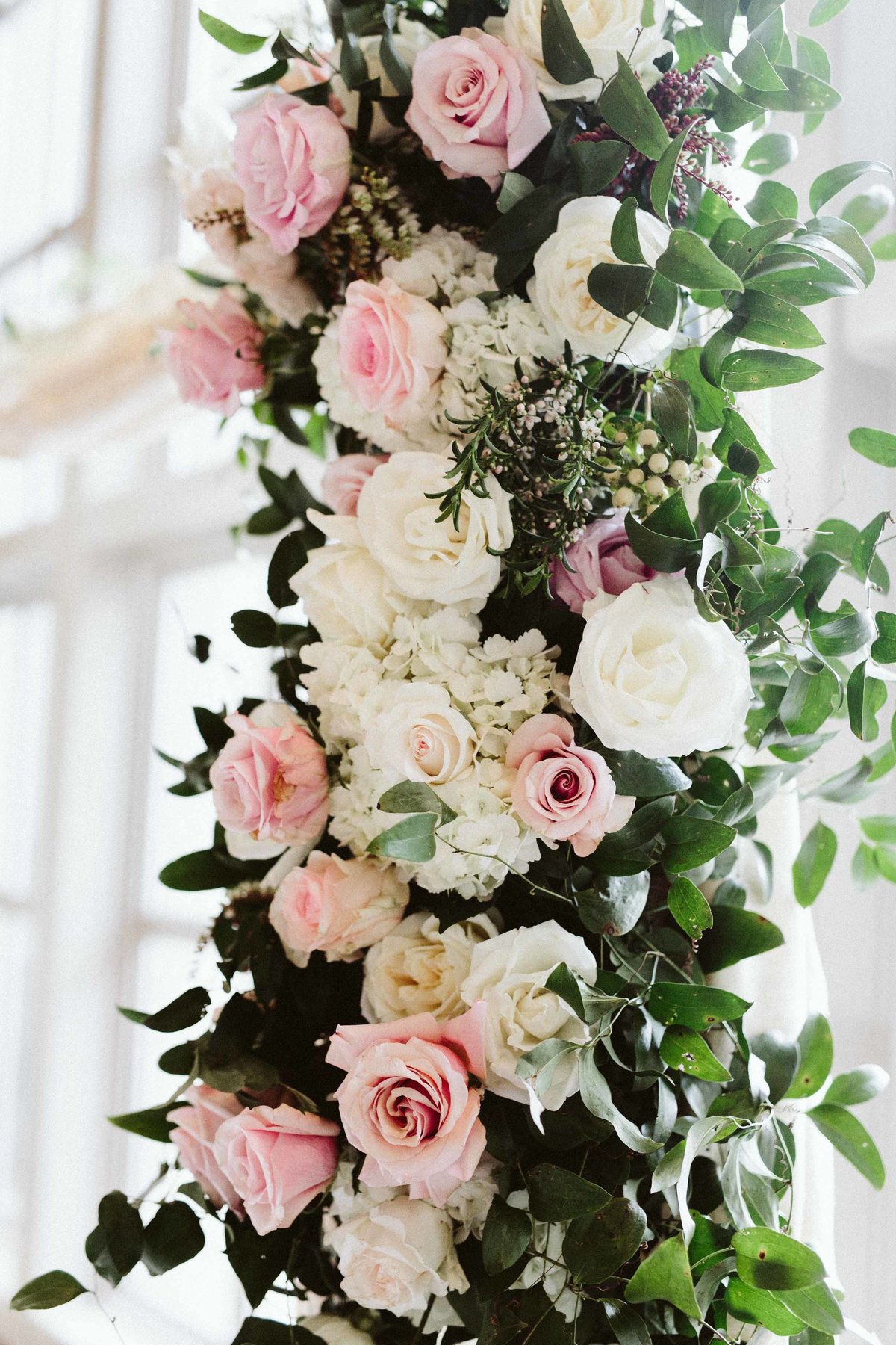 pink and white flower arch detail with roses, hydrangea and greenery