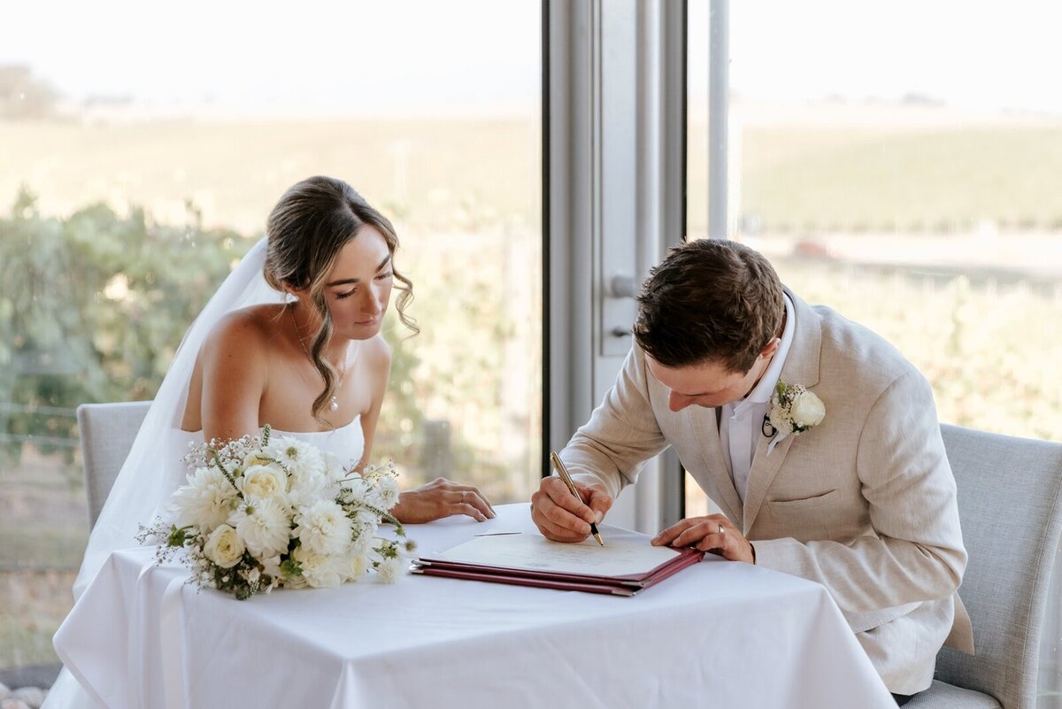 Couple signing their marriage certificate at their elopement in Melbourne