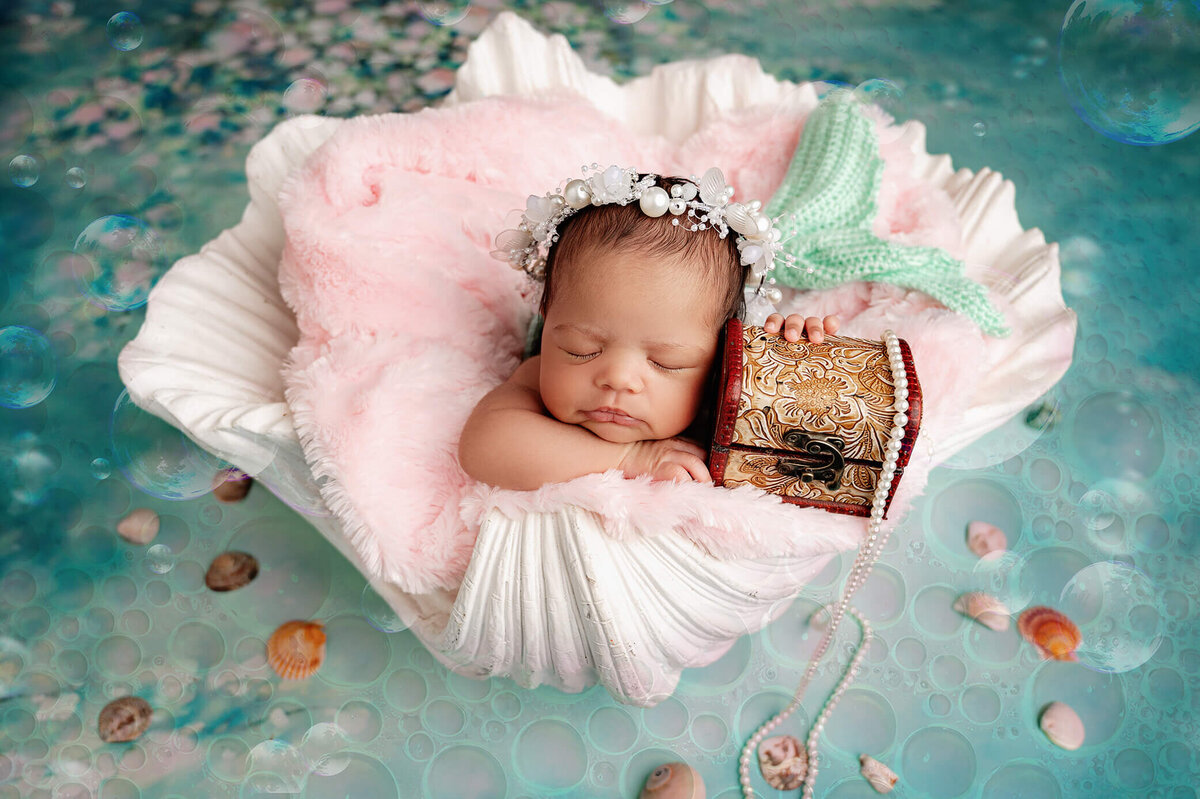 Newborn girl at Toronto photographer studio dressed as a mermaid posed in a shell prop.