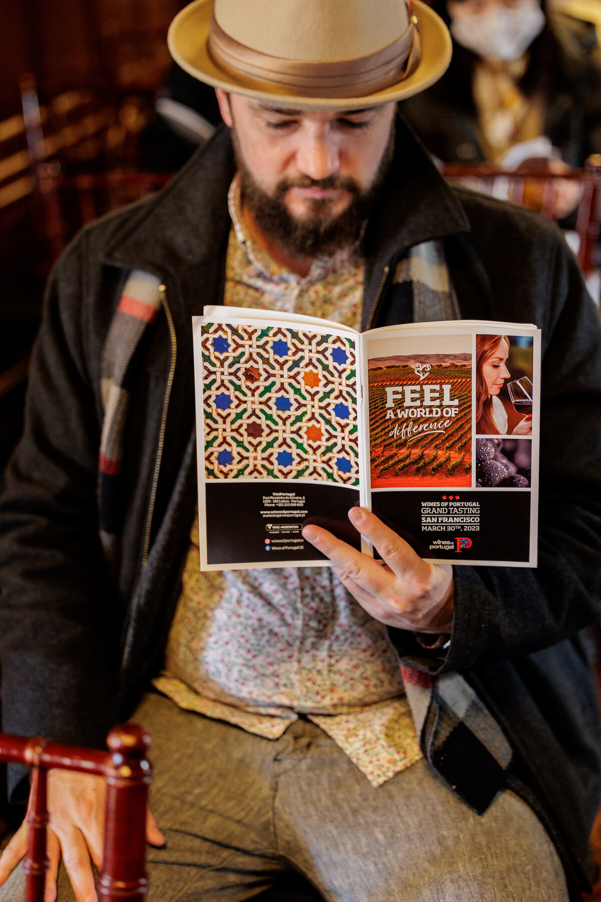 Man with a hat reading the brochure