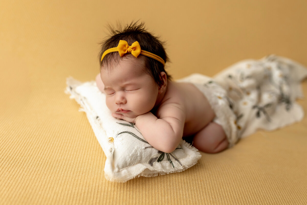 Newborn on yellow backdrop