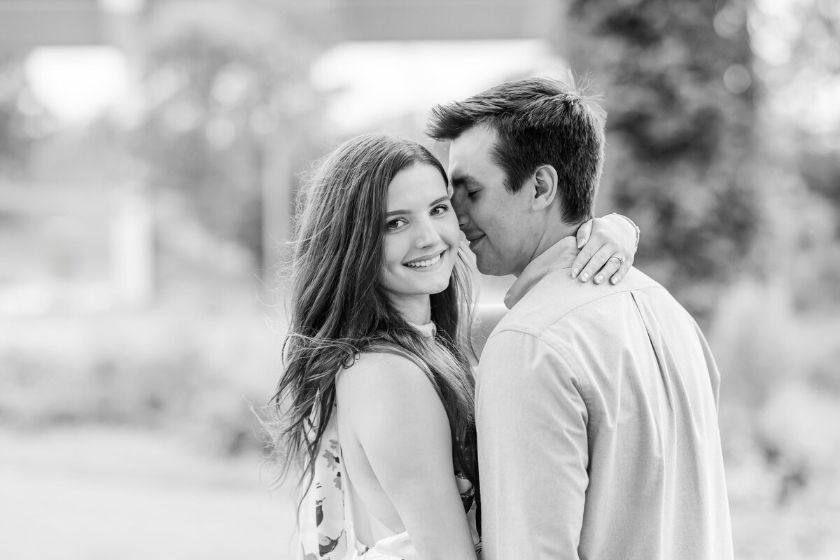 A black and white image of an Arkansas couple hugging and smiling in a garden