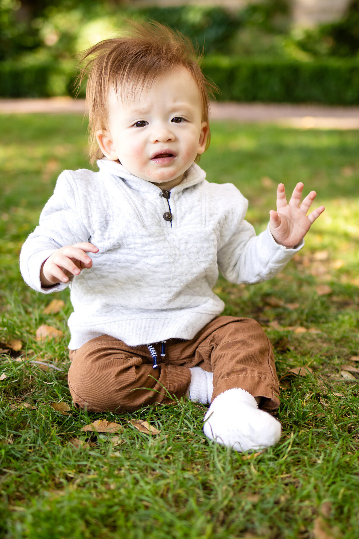 Bay Area Family Portfolio - Ellobelle Photography captures expressive baby sitting in grass with soft fall light.