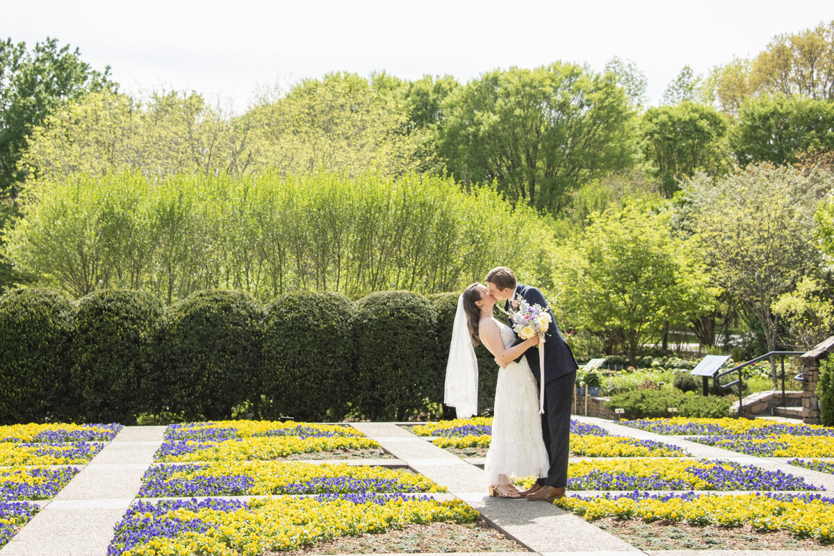 Couple kissing in quilt garden at NC Arboretum wedding
