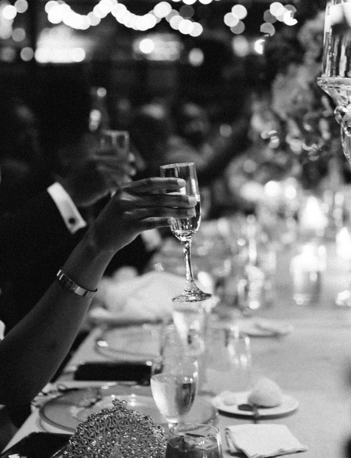 detail of guest holding champagne glass, candlelit reception at Garden Theater Detroit