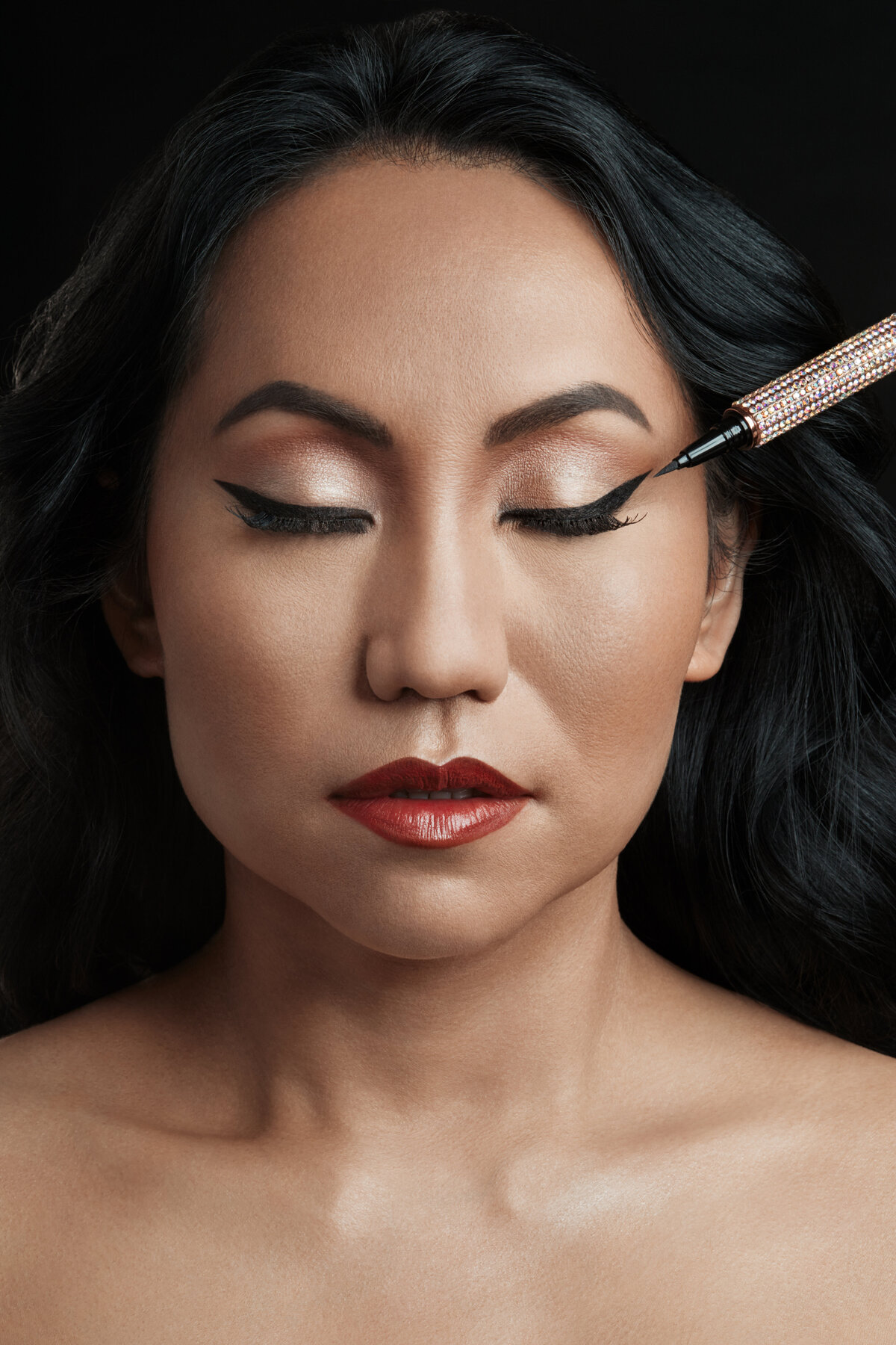 Close-up of a woman applying Giorgio Armani lipstick in a dramatic beauty portrait, captured by Ylva Erevall.