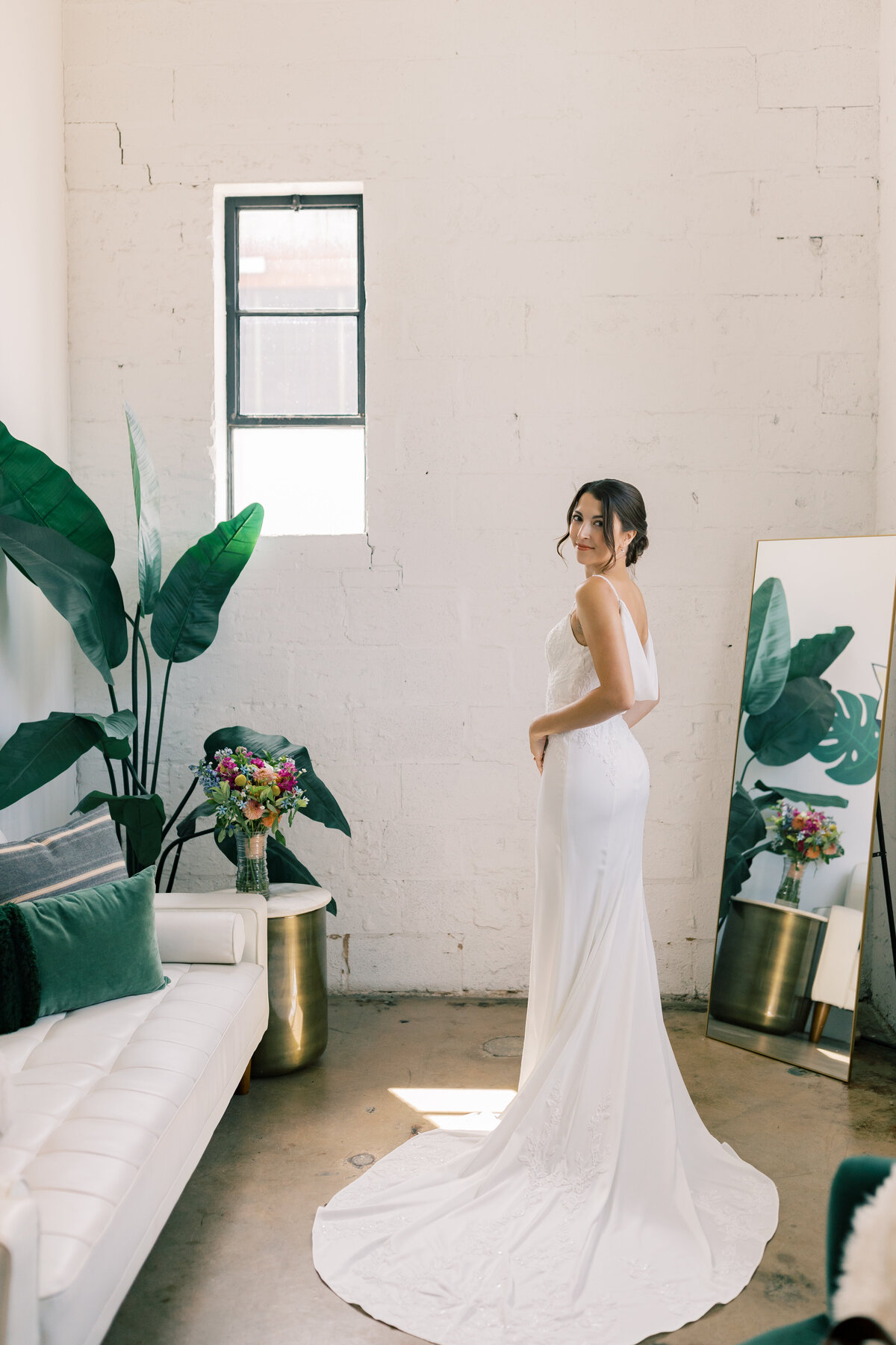 Sara in sleek lace gown from Bridal Chateau posing indoors at Fetewell bridal suite in Baltimore, Maryland.