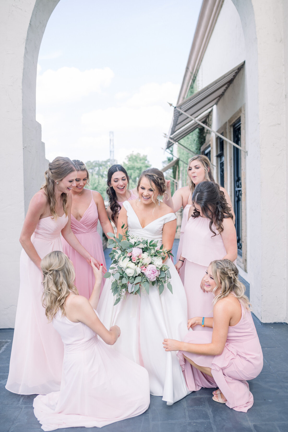 bride with pink bouquet and bridesmaids wearing pink dresses