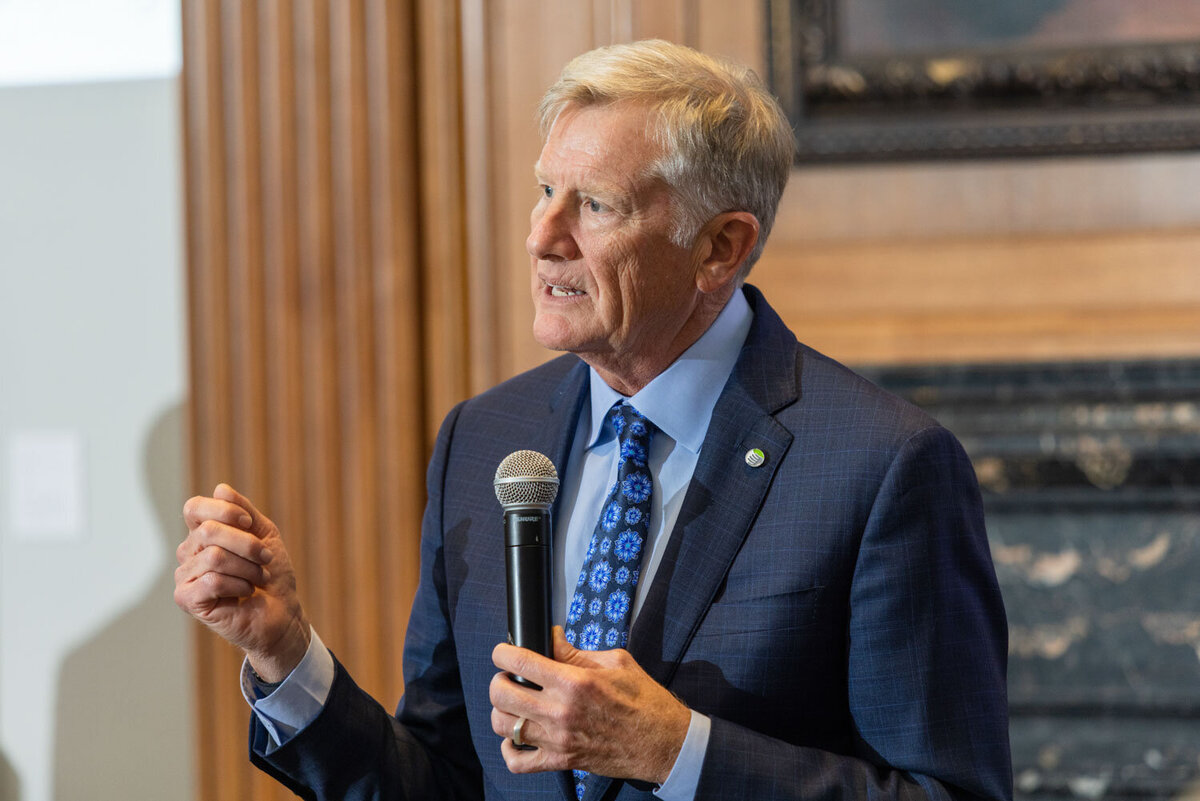 Man in blue suit speaking into a microphone