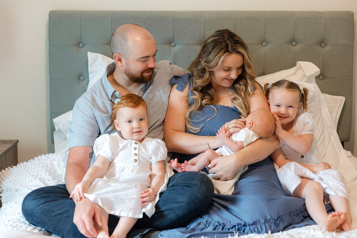 Family loving on their new baby brother during a lifestyle newborn session in Savannah, Ga
