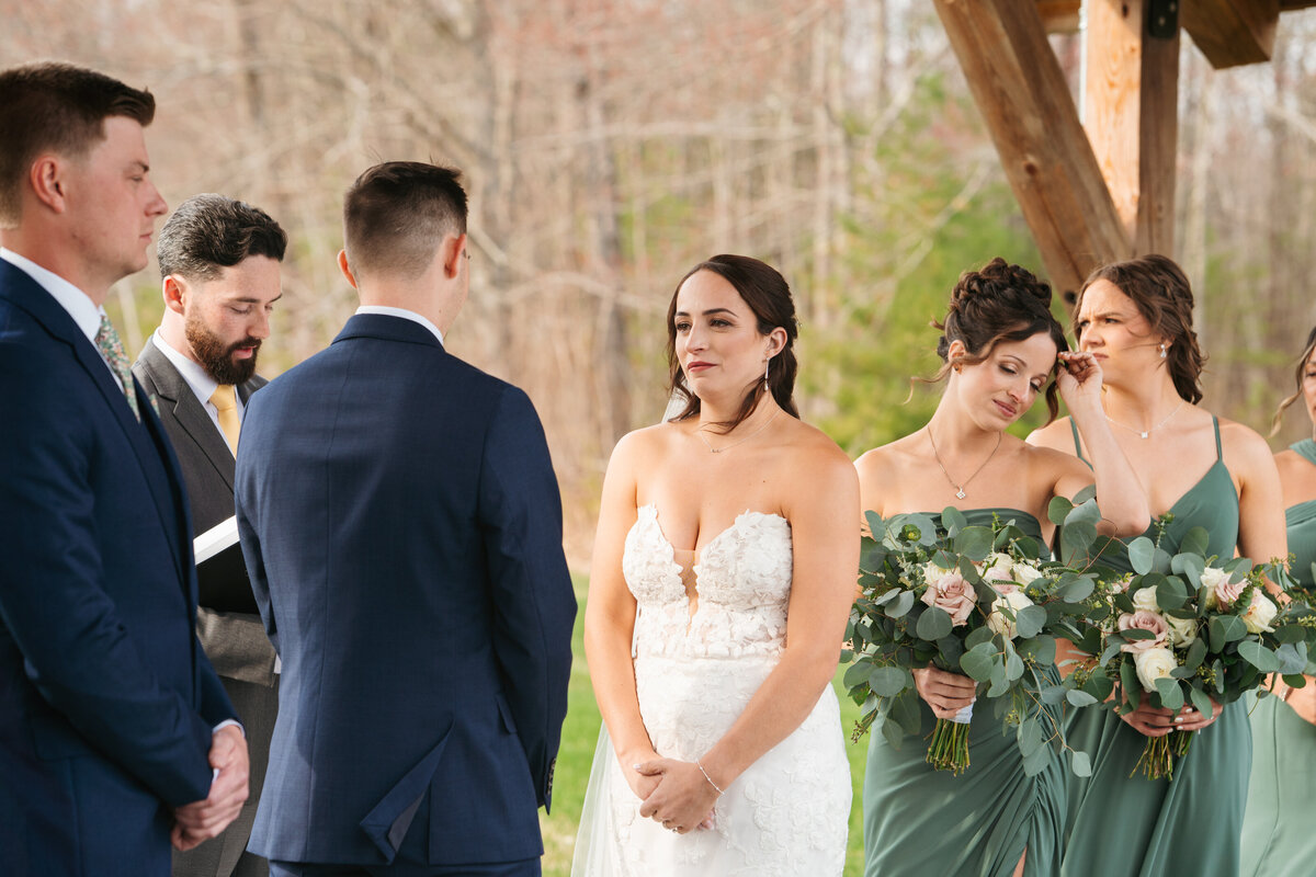 Bride putting on earrings in soft window light before her New England wedding