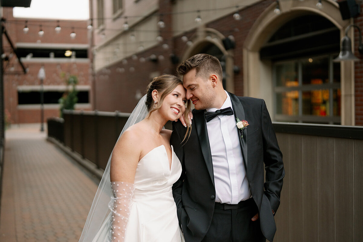 a photo of a bride and groom looking at each other during their bridal portraits downtown holland, MI