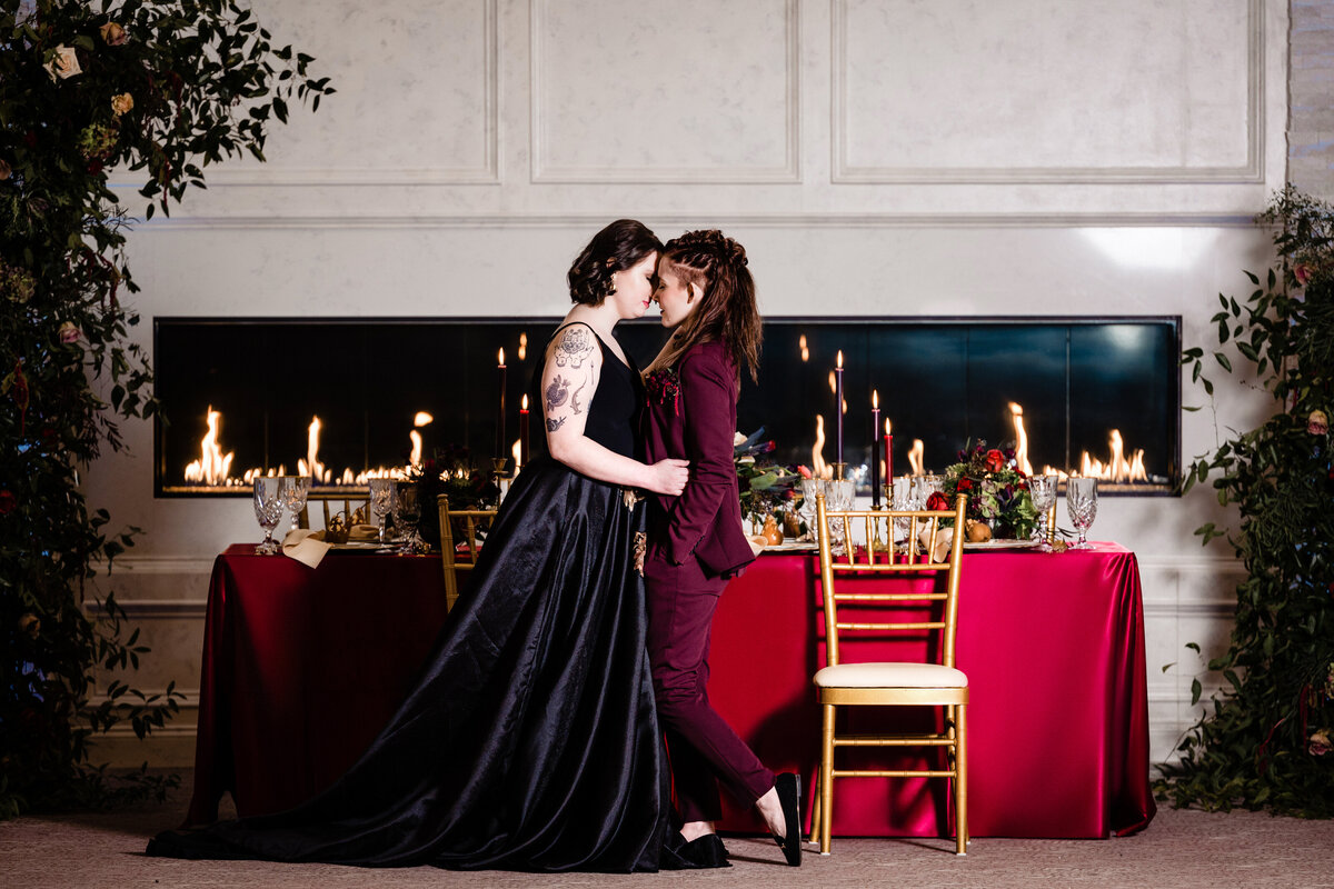 Two brides hugging in front of wedding table