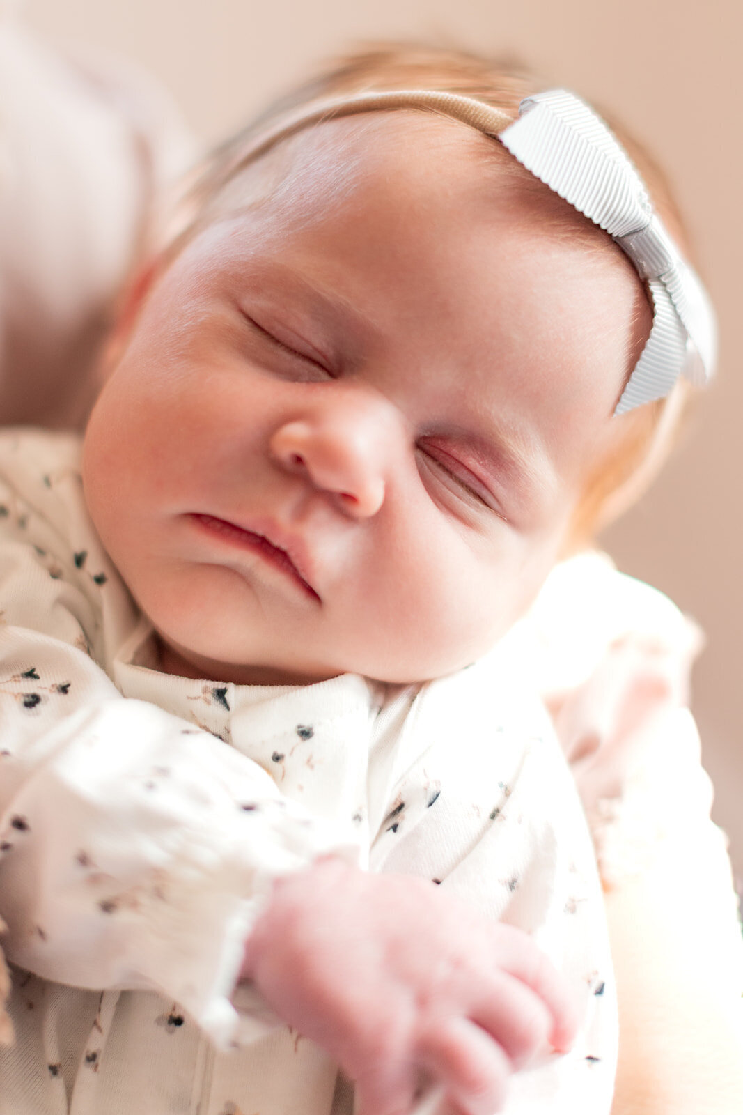 Mom holding newborn baby girl during in-home session