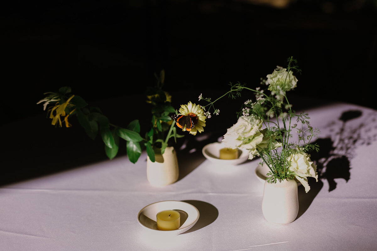 Florals and candels set upon white table at Mattie's wedding venue in Austin