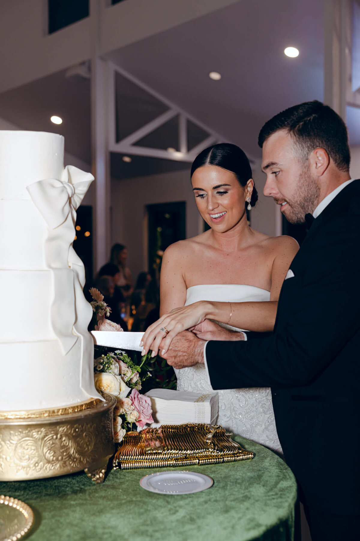 A candid wedding photo of the bride and groom cutting their wedding cake