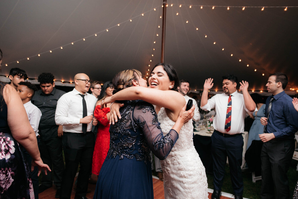 bride and mother of the groom dancing under tented reception in boston