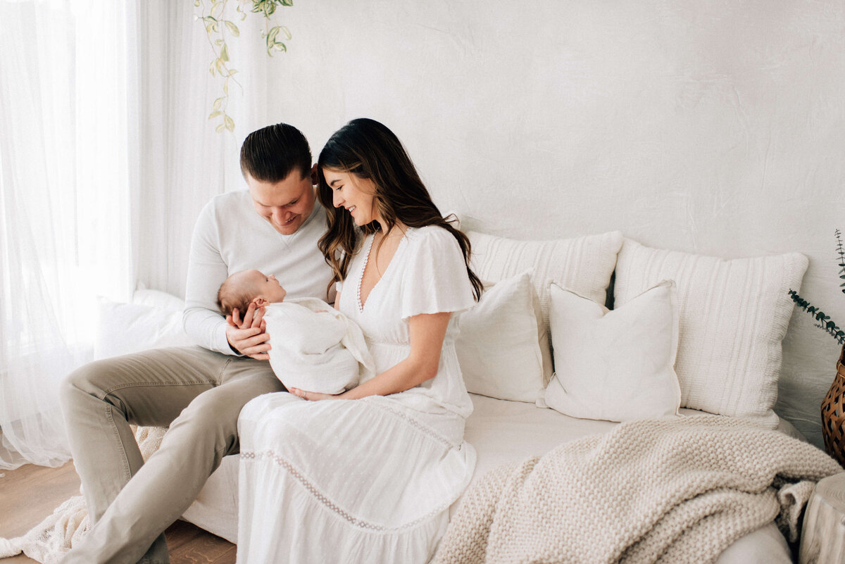 mom and dad holding their newborn swaddled
