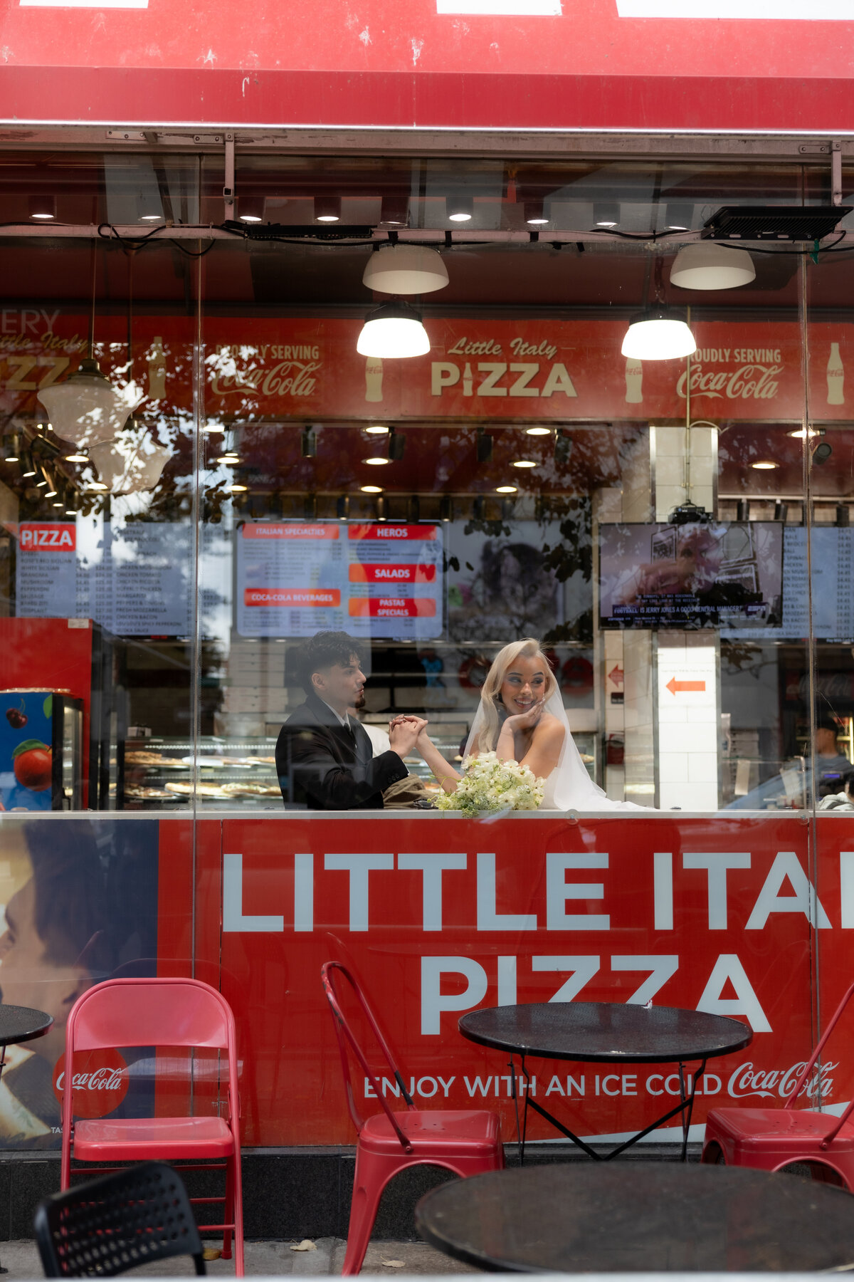 Neon sign glowing in an NYC pizza shop, captured during the couple’s urban elopement session.