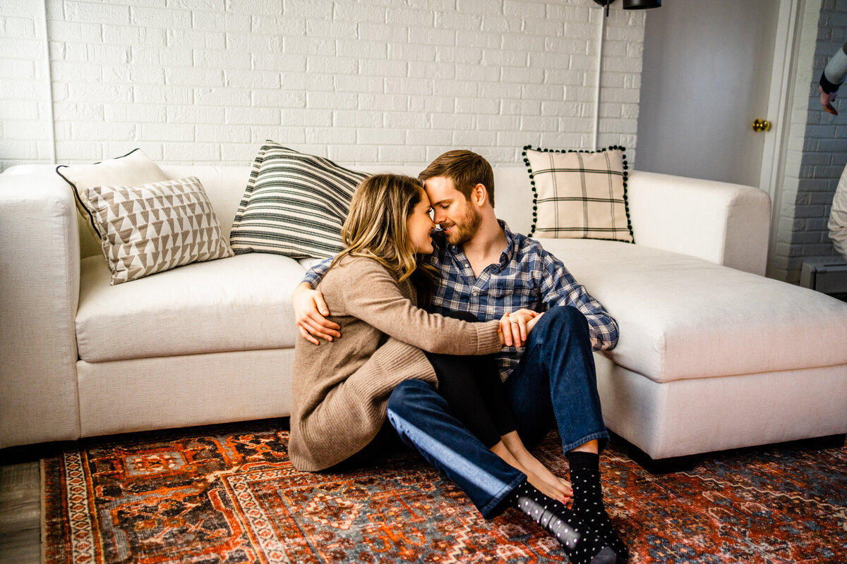 Couple snuggled together on a couch with playful energy