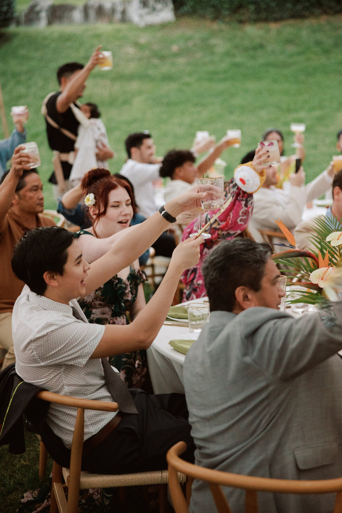 Guests cheering and raising their glasses to celebrate the couple, captured in a candid moment with a documentary wedding photography style — Carmel wedding photography by Kate Winters Photography.