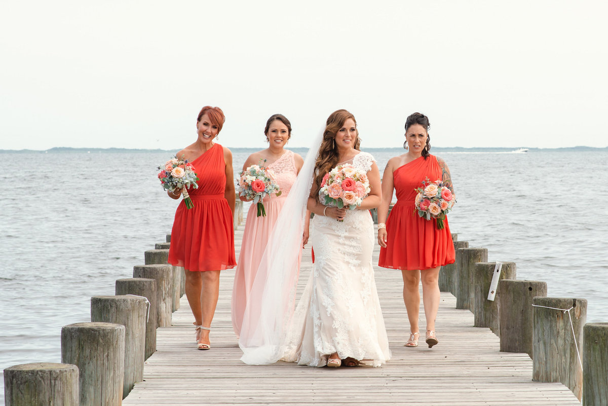 photo of bride with bridesmaids and maid of honor on the dock from wedding at Lombardi's on the Bay