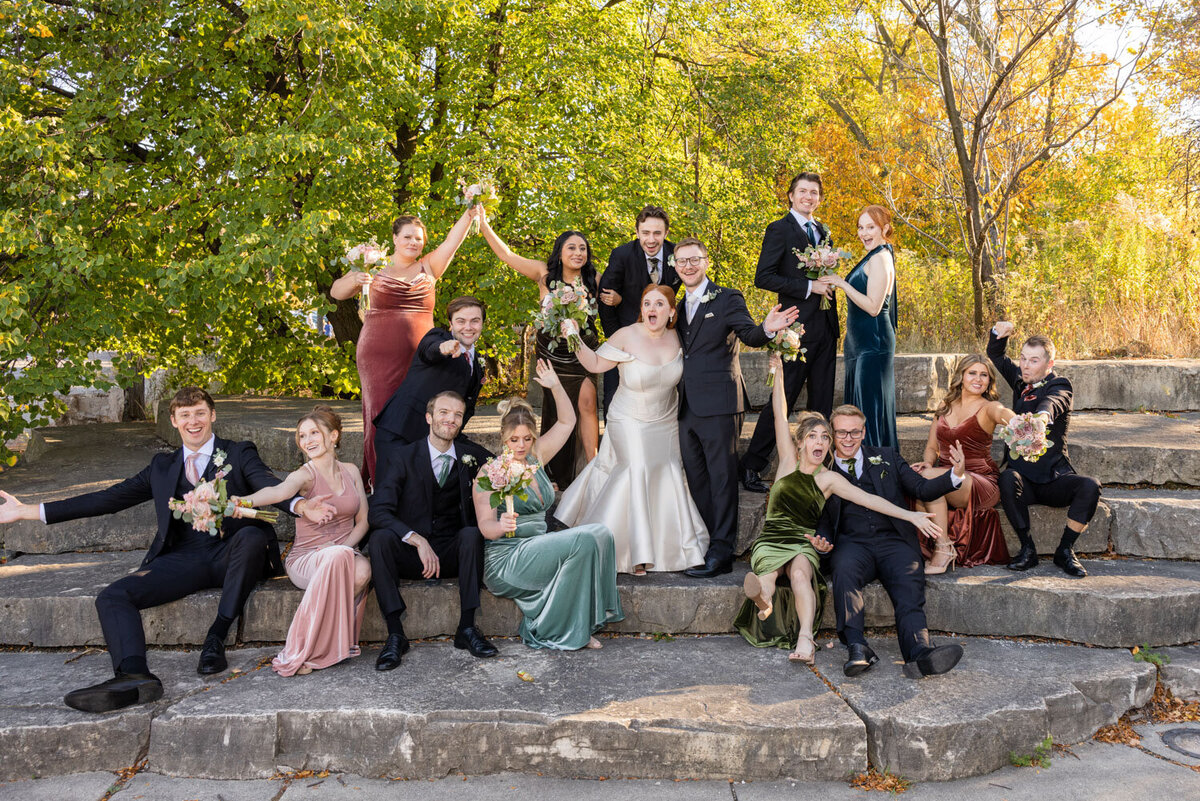 The bride and groom are posing for a picture with their wedding party.