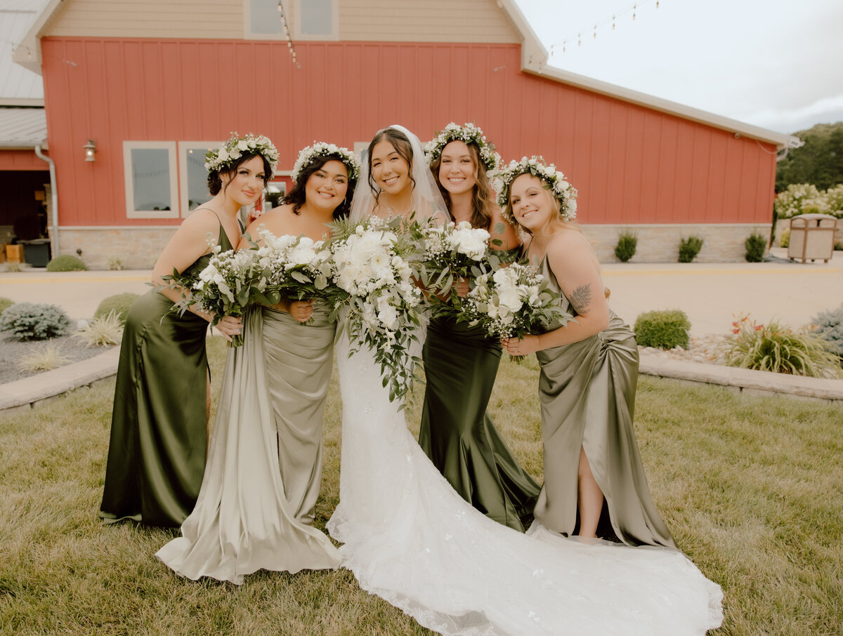 bride and bridesmaids posing together during outdoor missouri wedding day