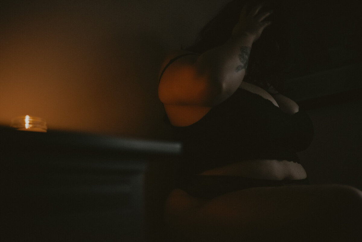 girl in lingerie lit by candle light