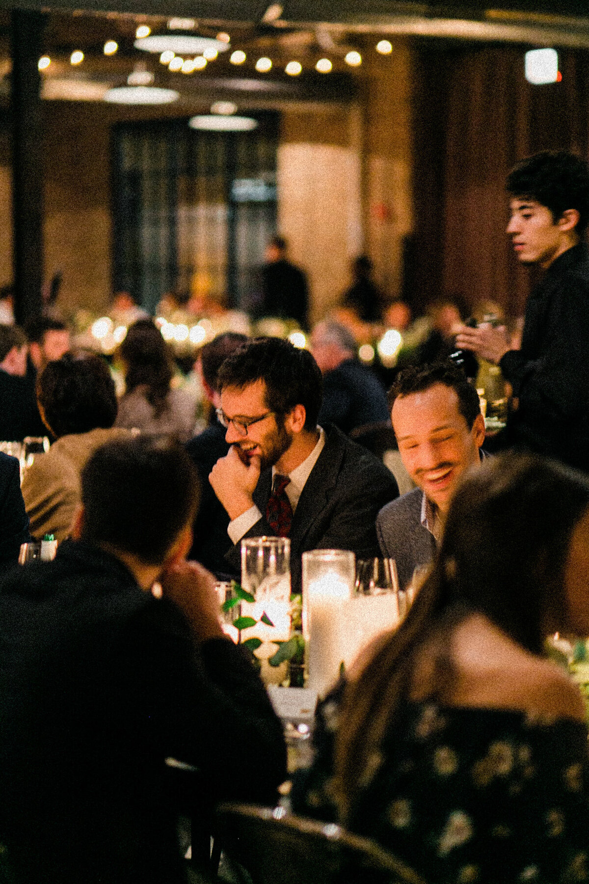 Guests laugh at dinner during a wedding reception in Chicago