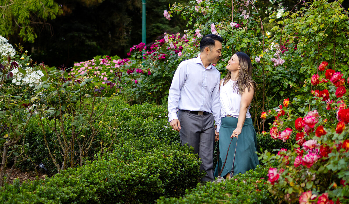 A joyful couple's portrait session in a blooming garden during golden hour