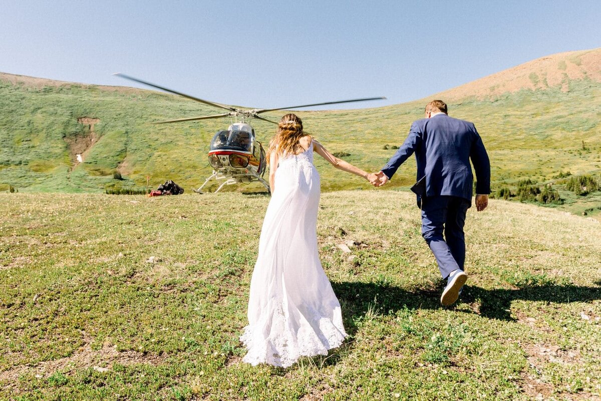 Alpine-helicopter-in-Canmore-with-bride-and-groom-walking-towards-the-helicopter