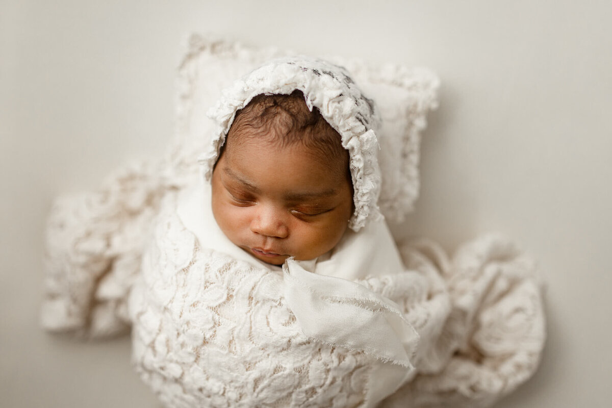 atlanta newborn in all white swaddled lying on pillow