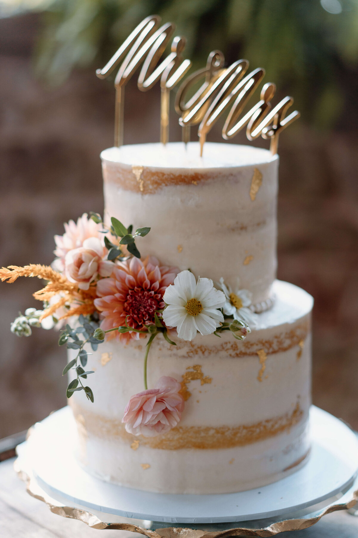 Naked style wedding cake with mr and mrs sign and florals