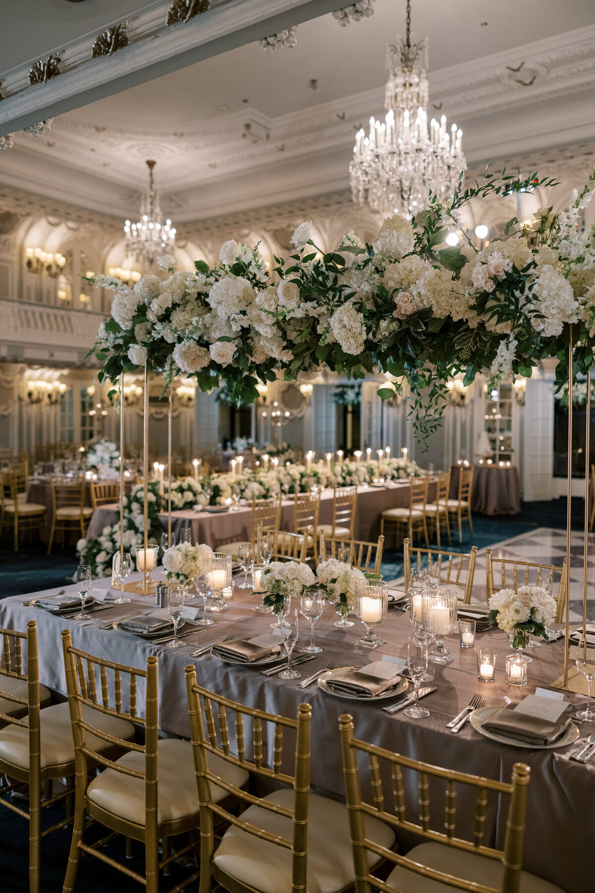 Elegant reception tables with floral arrangements and candlelight at the Blackstone Hotel, planned by Chicago wedding planner Savoir Fête. The ambiance is luxurious and inviting.