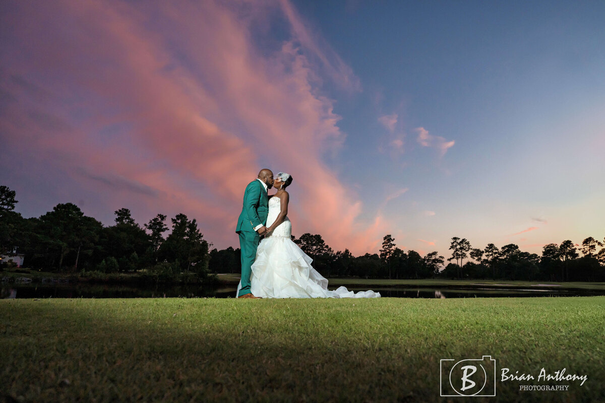 Bride and groom sharing a tender moment as the sun sets over their wedding venue.