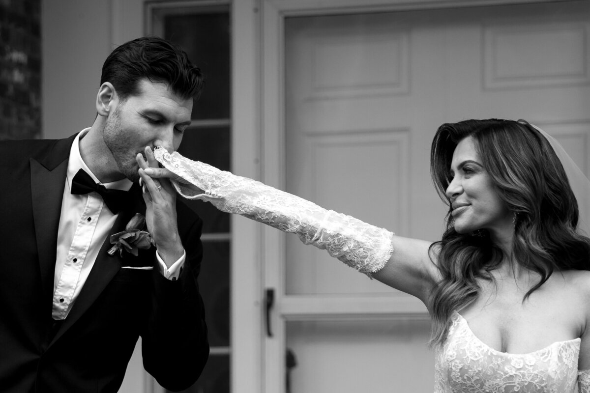 Wedding Photographer in Vermont | Sincerely Liz Photography Documentary Wedding, Engagement, Elopement, Maternity and Newborn Photographer in New England | Groom kissing bride's hand in front of a New England mansion wedding venue