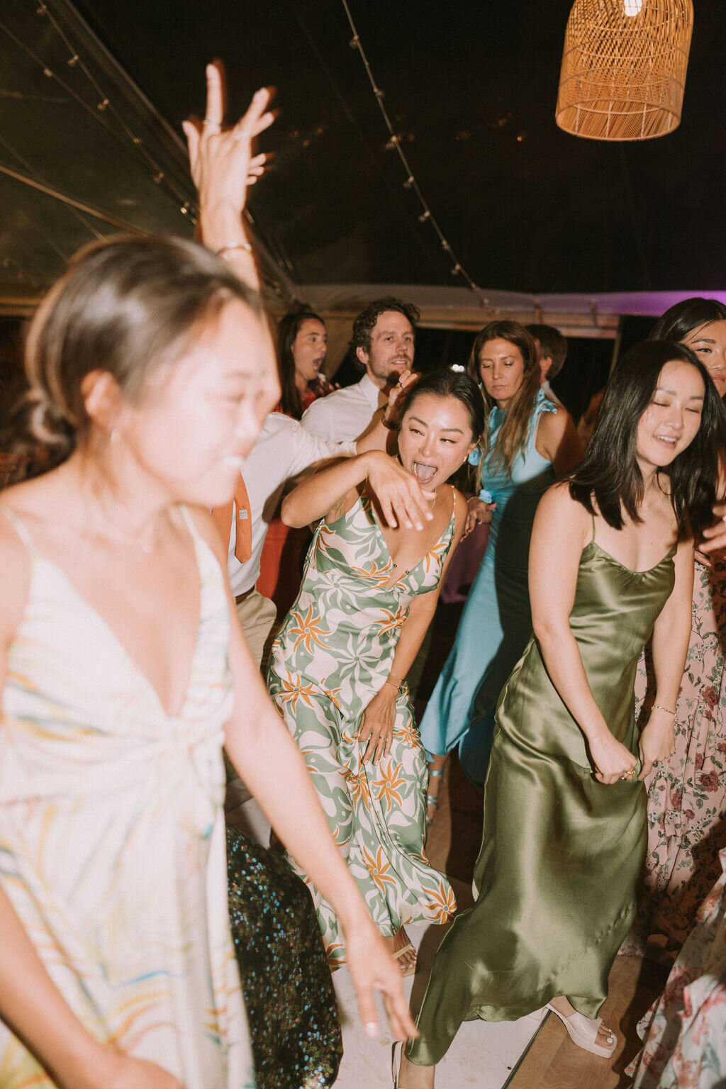 wedding guests in multicolor spring dresses dancing at lanikuhonua wedding reception