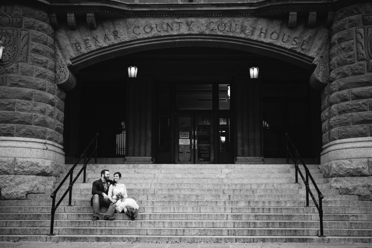 Bride and groom sitting on the steps of Bexar County Courthouse after getting married taken by Expose the Heart Photography