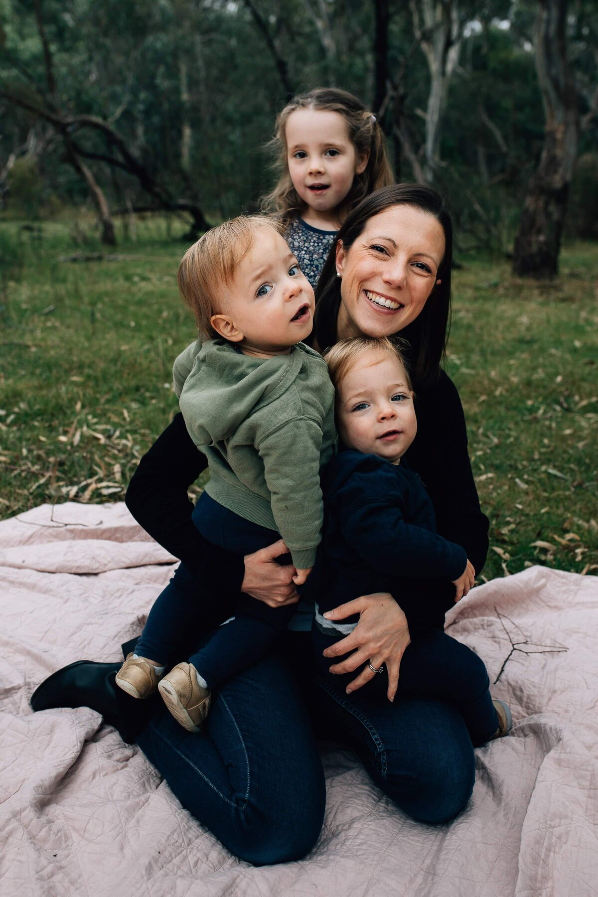 Mum sitting outdoors, surrounded by her kids, Family Photography Gift Vouchers Melbourne