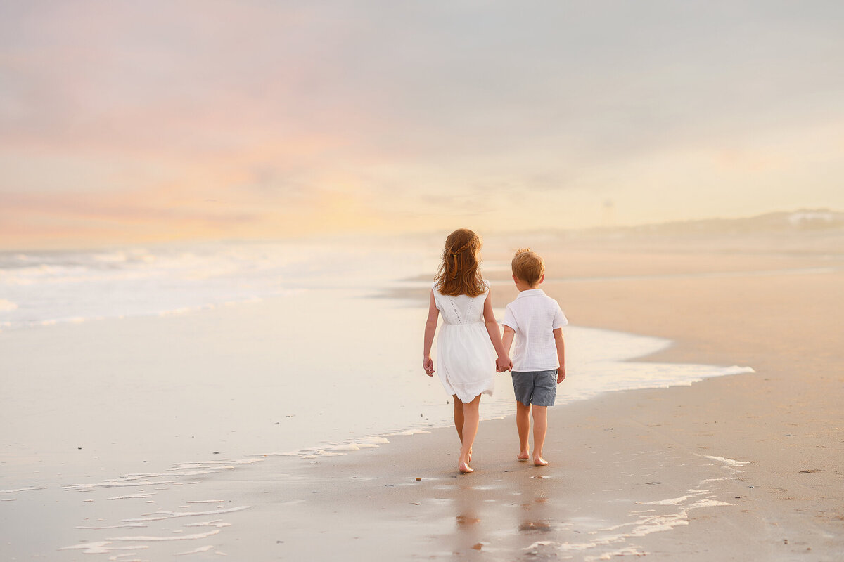 Siblings walk along the beach together during Family Pictures on Isle of Palms. 