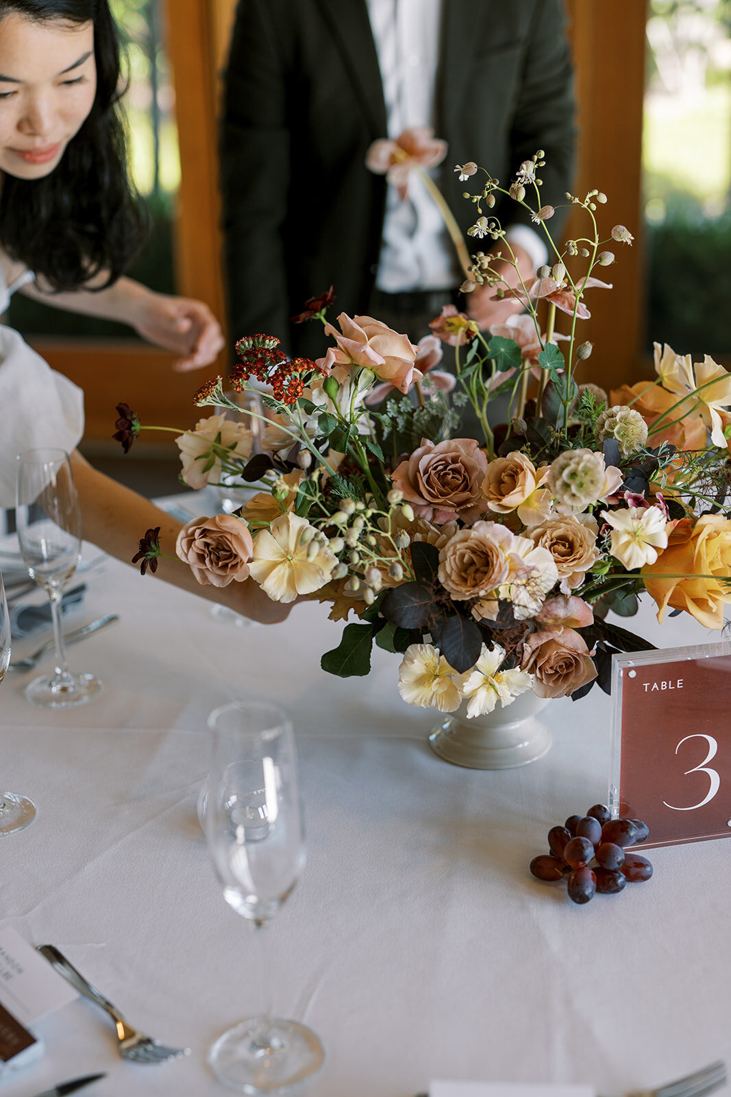florist adjusting lush centerpiece at east bay wedding reception