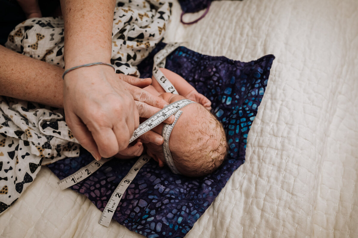 midwife measuring newborns head