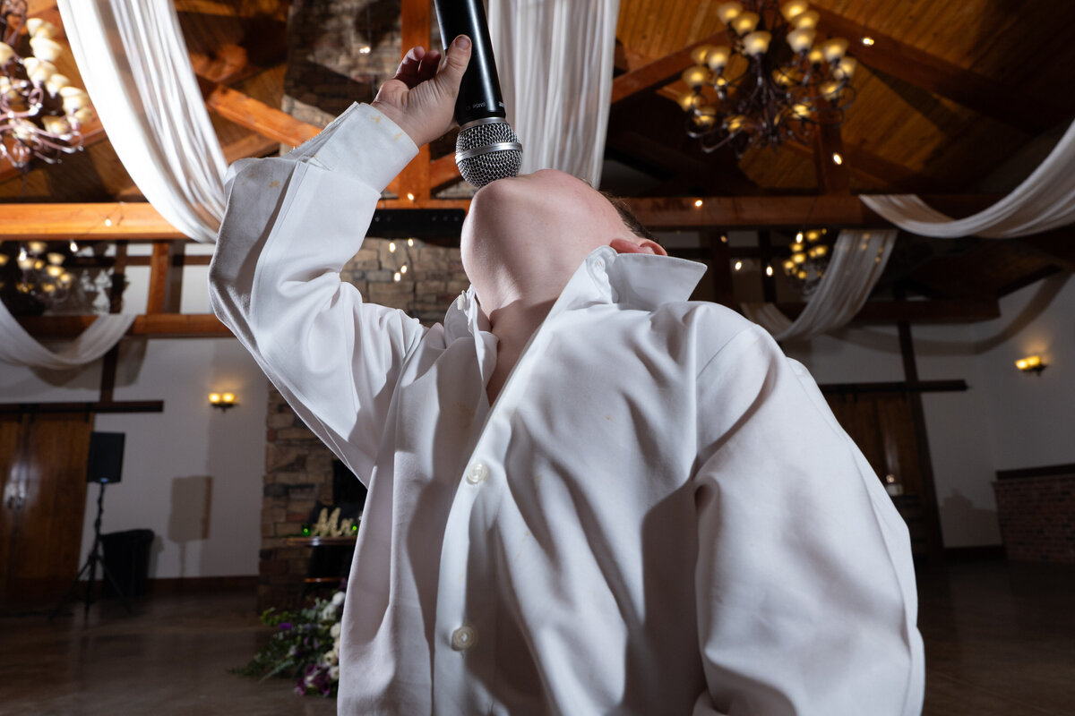 A young child singing into a mic at a wedding reception 