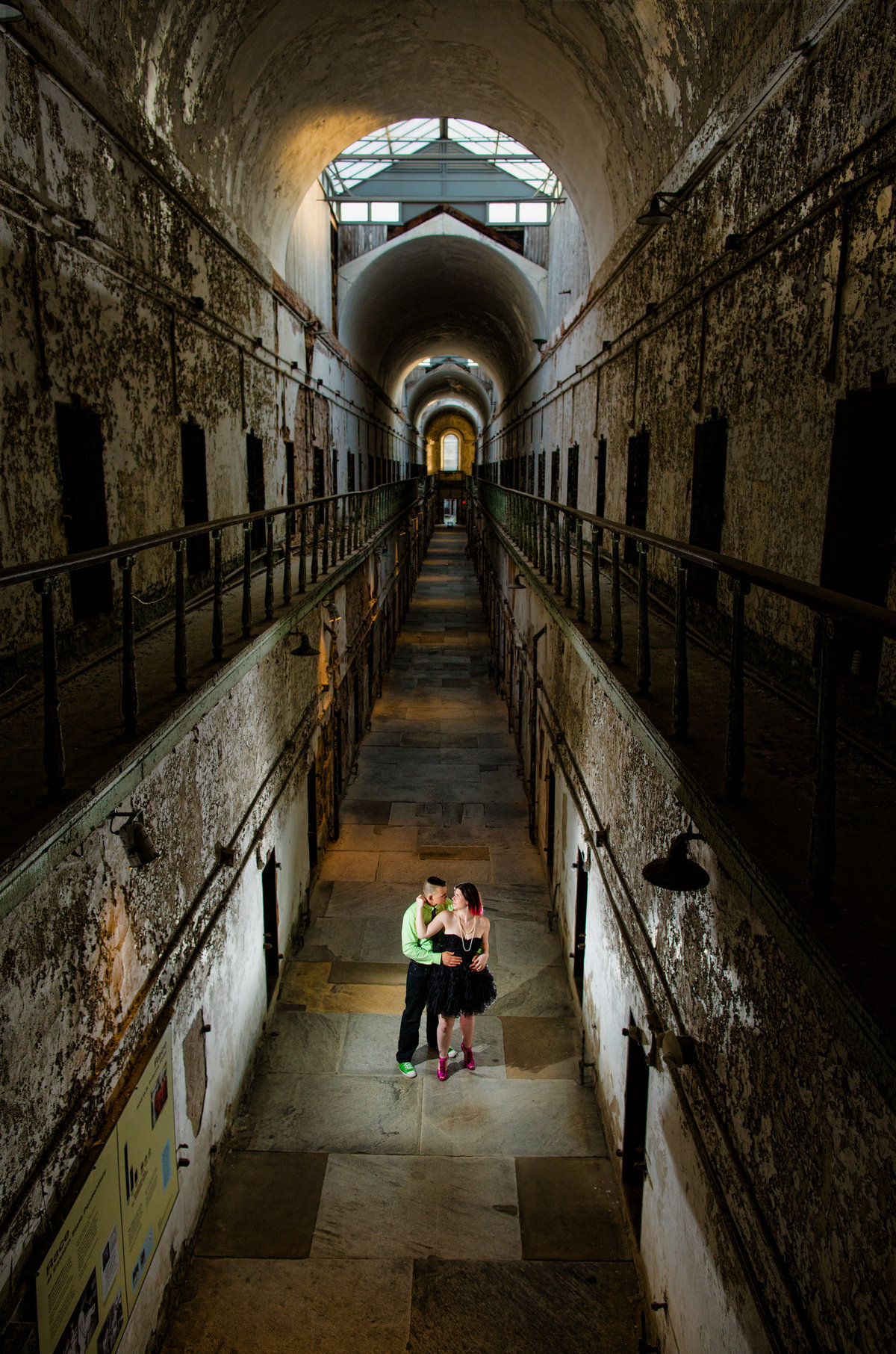 An engaged couple exploring the hauntingly beautiful historic site of Eastern State Penitentiary during their engagement session, creating dramatic and distinctive photos with a touch of intrigue.