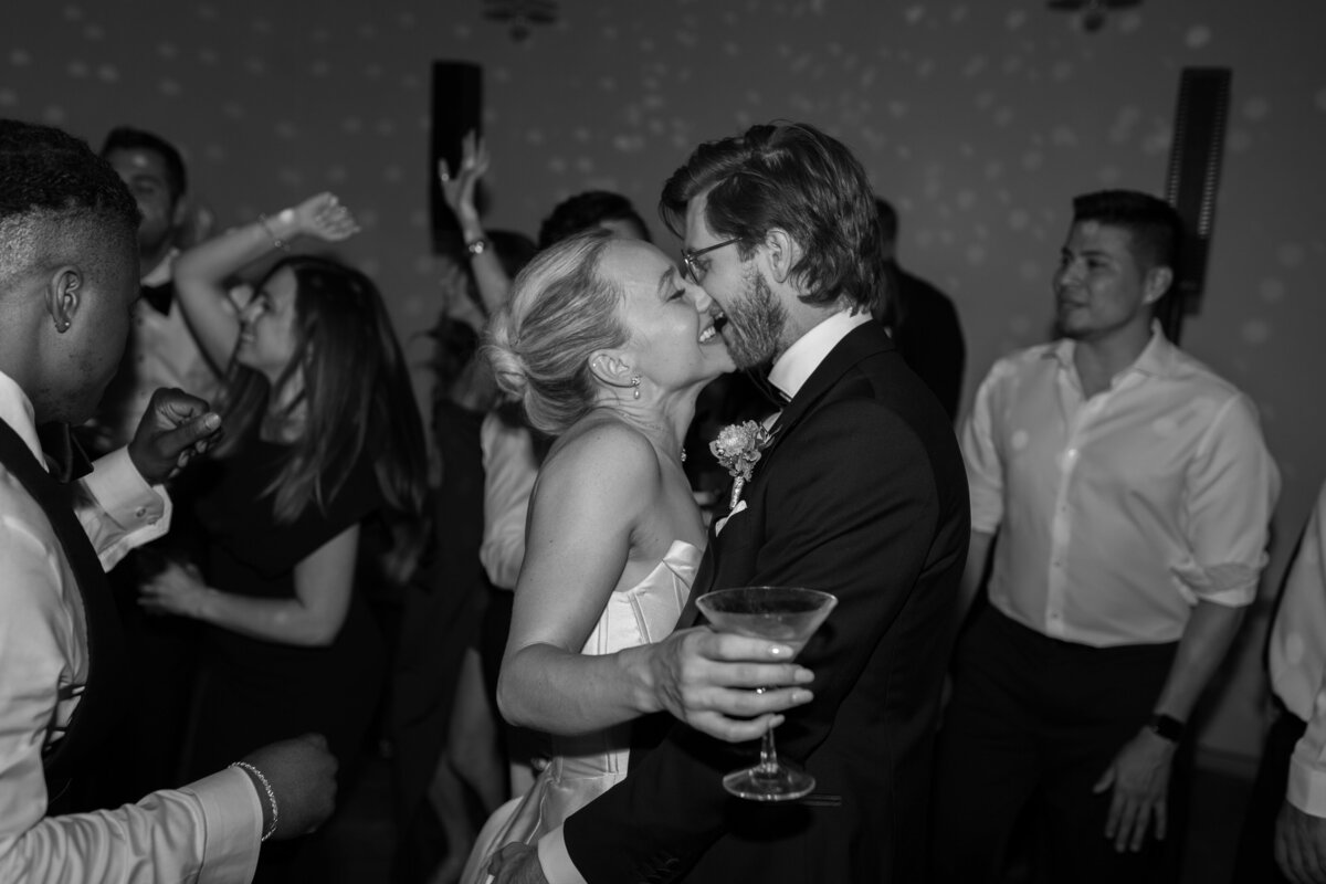 The bride and groom share a kiss on the dance floor