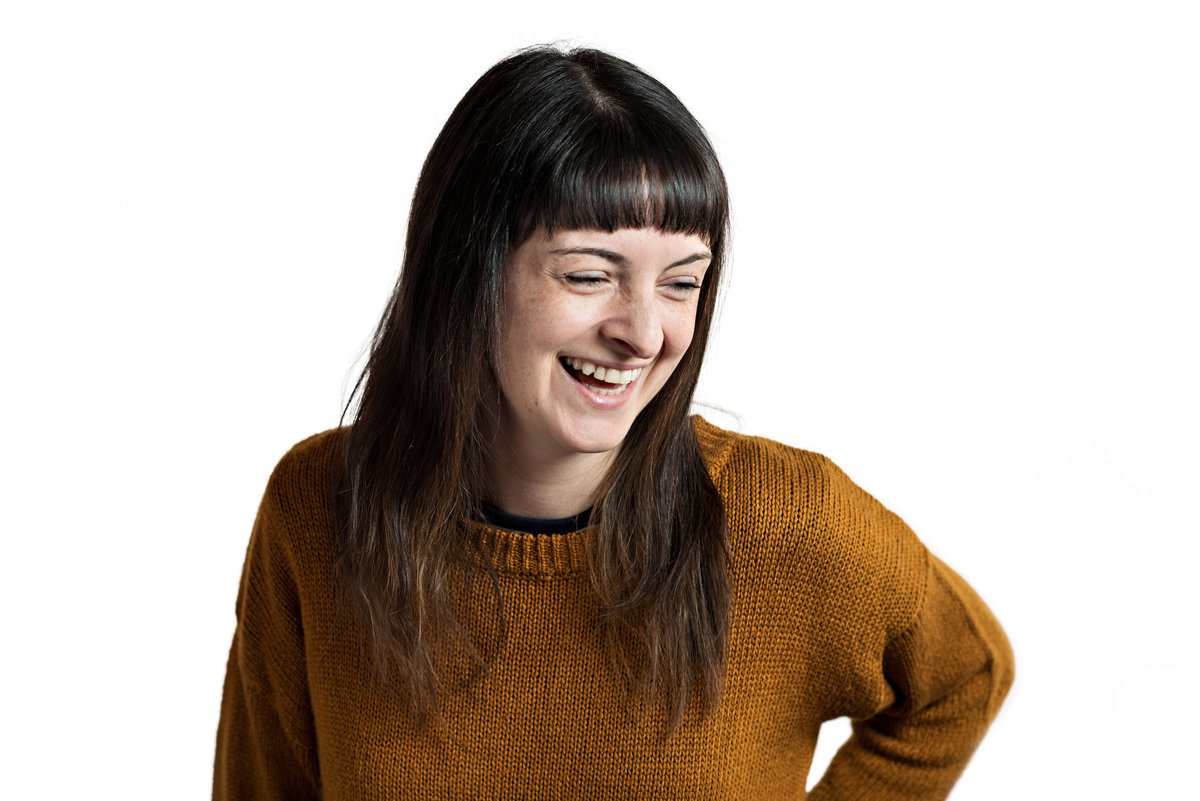 A headshot of a woman laughing for her social media websites.