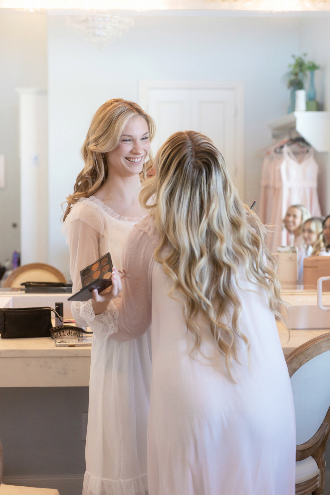 Candid shot of the bride with her bridesmaid, wearing a romantic gown