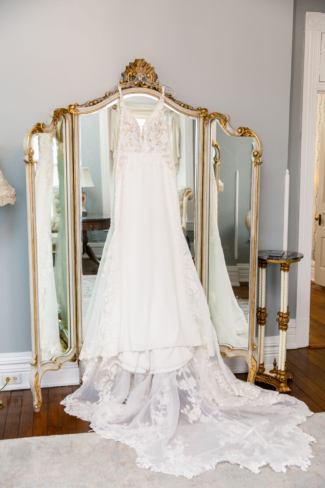 Gorgeous wedding dress hanging from mirror in the bridal suite at Ceresville Mansion. Captured by Bethany Aubre Photography.