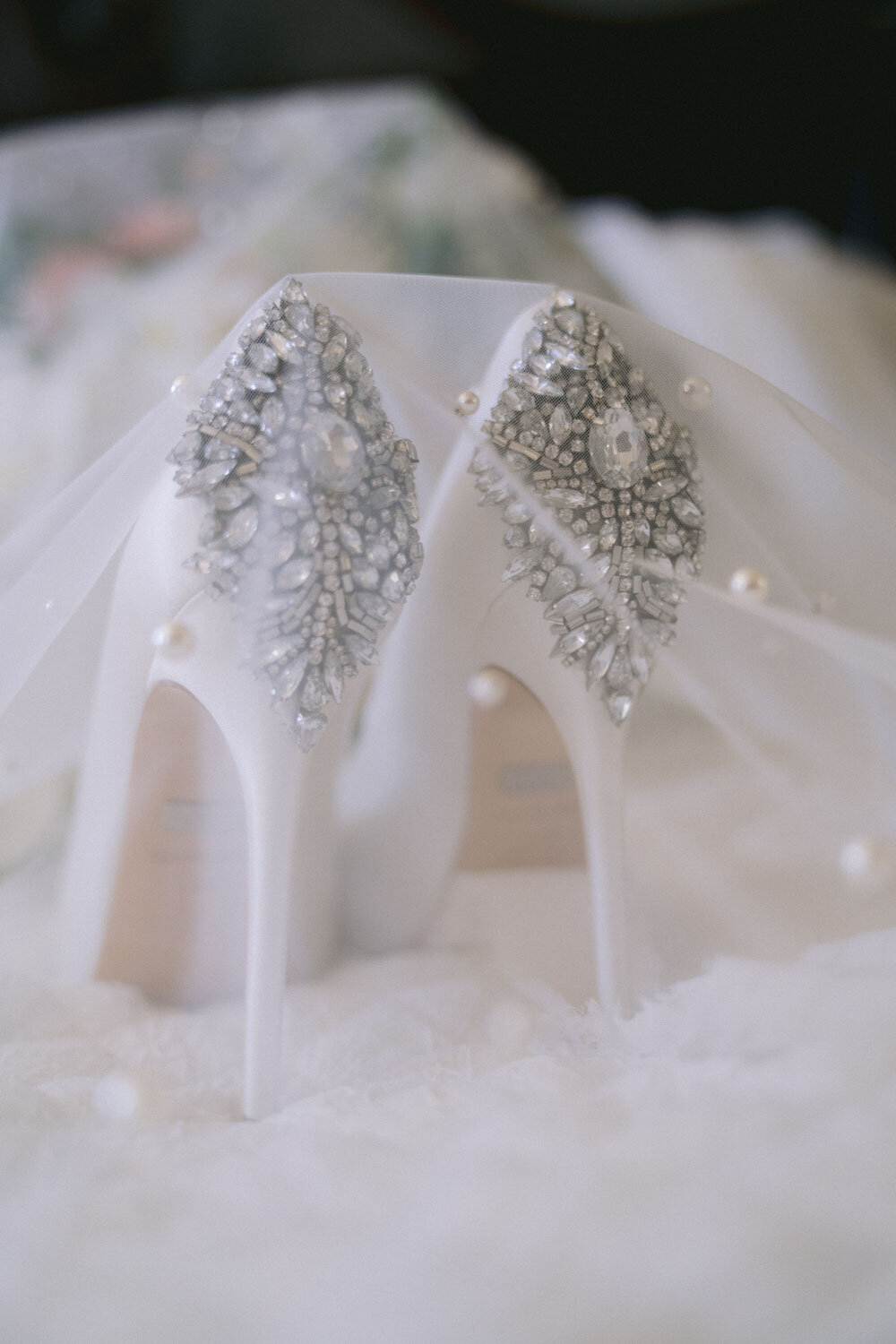 White high heels with intricate rhinestone details on the heels